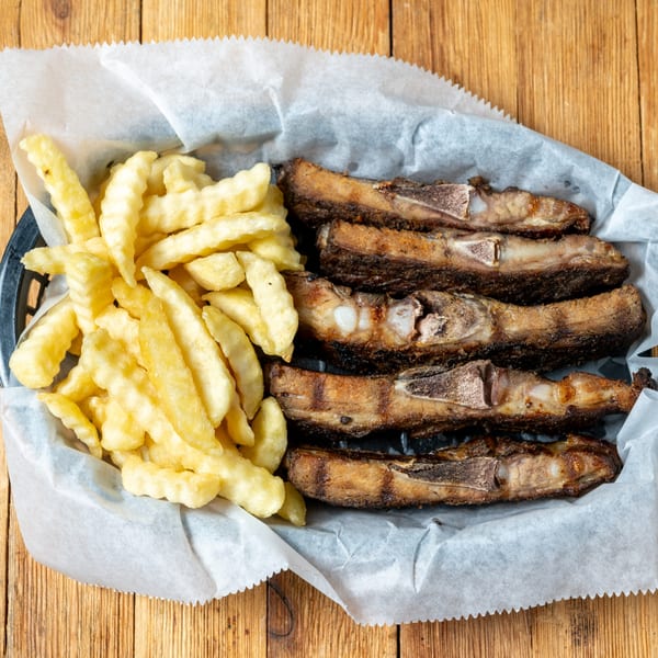 A basket of J.R. Crickets' crispy crinkle-cut fries and five grilled rib pieces.